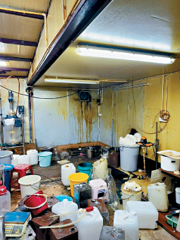 搗破的製毒實驗室骯髒凌亂，地上放滿大量用於疑盛載原材料和化學物品的膠桶及鐵桶。