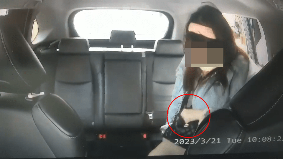 司機協助女子打開車門，這時女子將左手握著的物件，放入袋中。