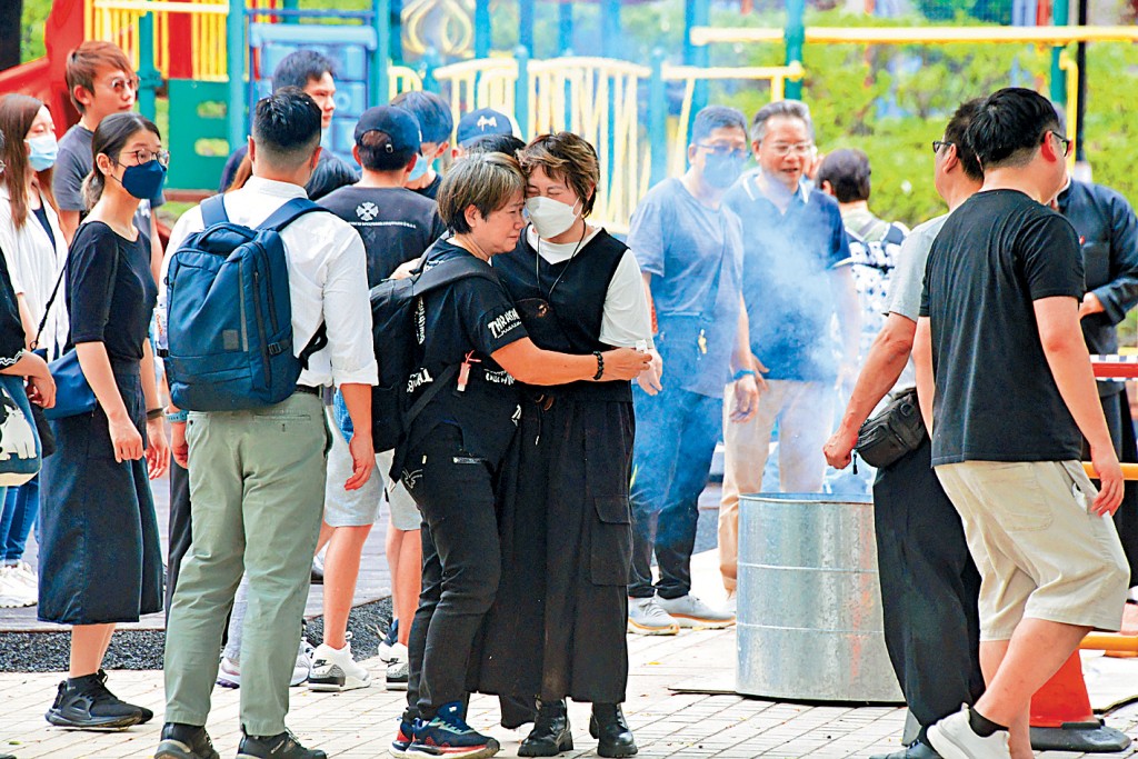 死者郭梓賢的20多名親友到達意外現場路祭,兩名哭成淚人的女親友互擁安慰,場面令人心酸。