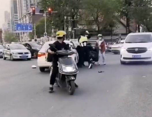 天津两名交警无视车来车往，在街道中央互殴。
