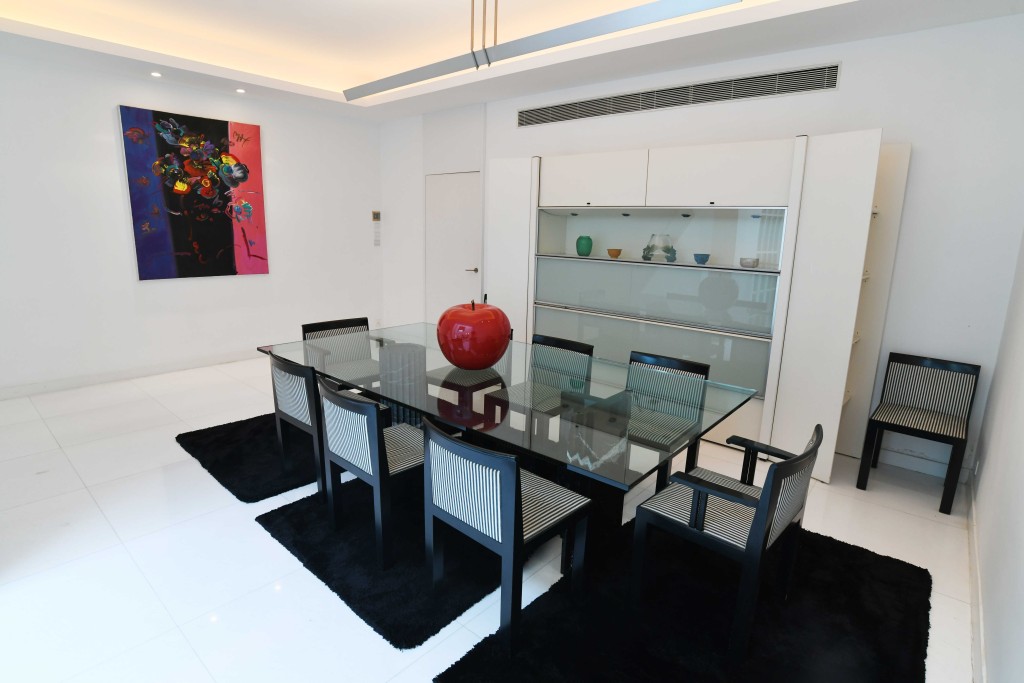 廳堂擺放長形玻璃餐桌,配以格紋餐椅,下方亦鋪上深色地氈。