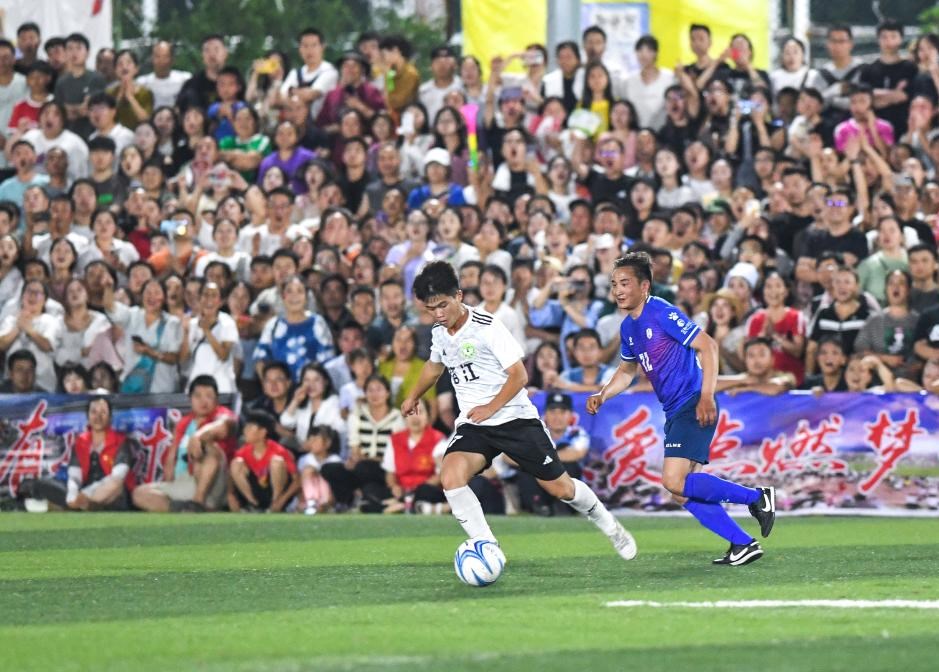 6月23日，贵州省榕江县足球队球员（左）与青海省果洛州格萨尔王足球队球员在友谊赛中拼抢。新华社