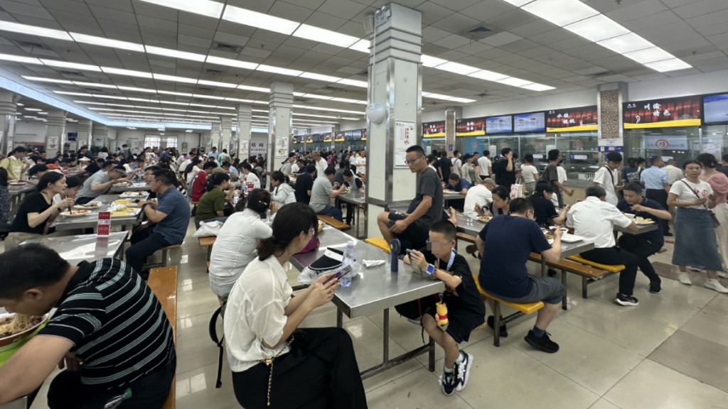 復旦食堂內不少遊客在用餐高餐時段,先霸位等夠鐘才購買食物,令師生無位開飯。澎湃新聞