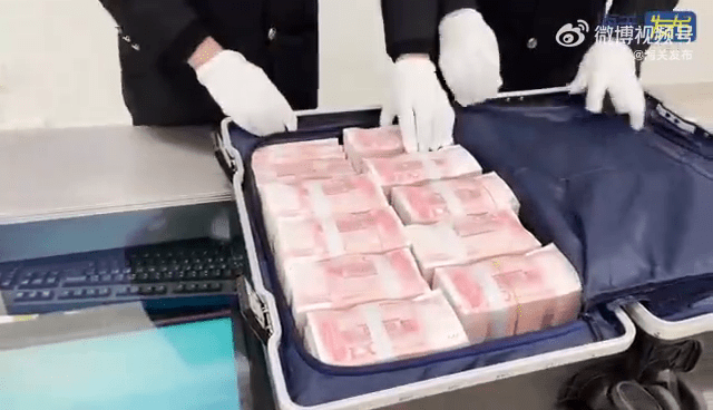 海关打开男子行李箱后，发现大量人民币现金。