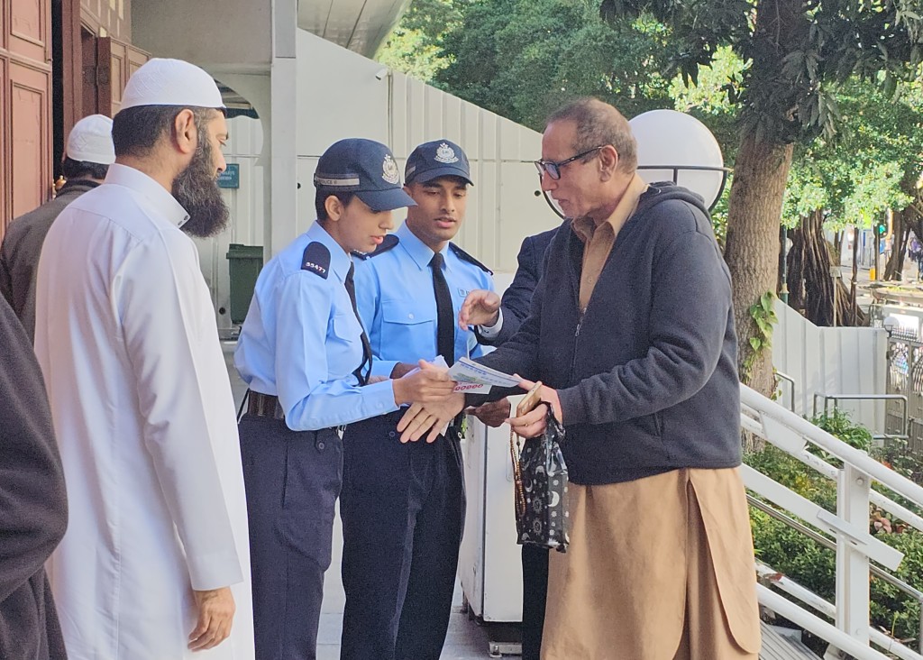 巴基斯坦籍警员莎玛(右三)和阿南文(右二)在清真寺门外向信徒派发防骗宣传单张。 徐裕民摄
