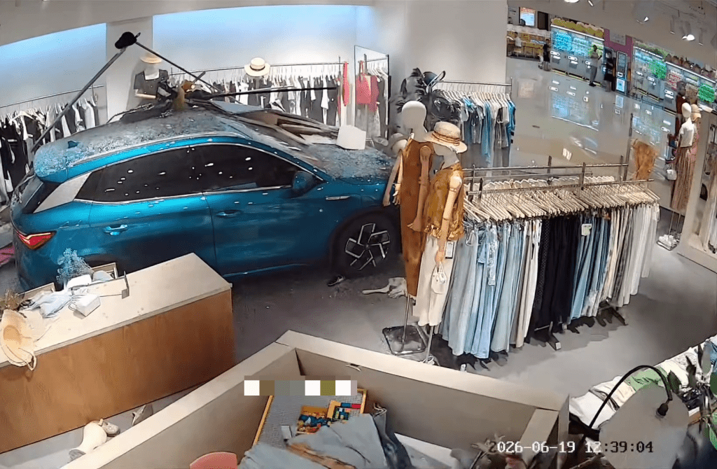 藍色SUV失控直衝入服裝店後終於停了下來。