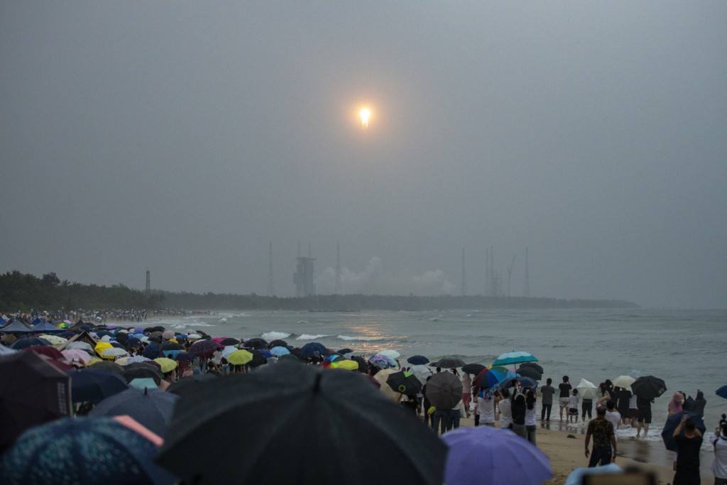 遊客在文昌海邊觀看火箭發射。