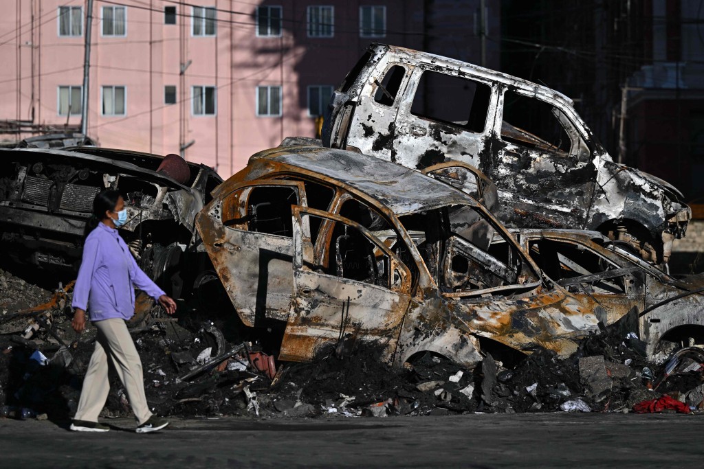加德滿都街頭滿布被示威者燒毀的汽車。法新社 加德滿都街頭滿布被示威者燒毀的汽車。法新社