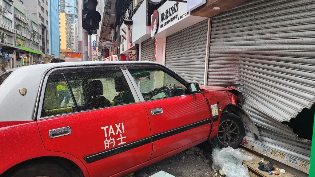 的士撞毀店舖鐵閘。黎志偉攝