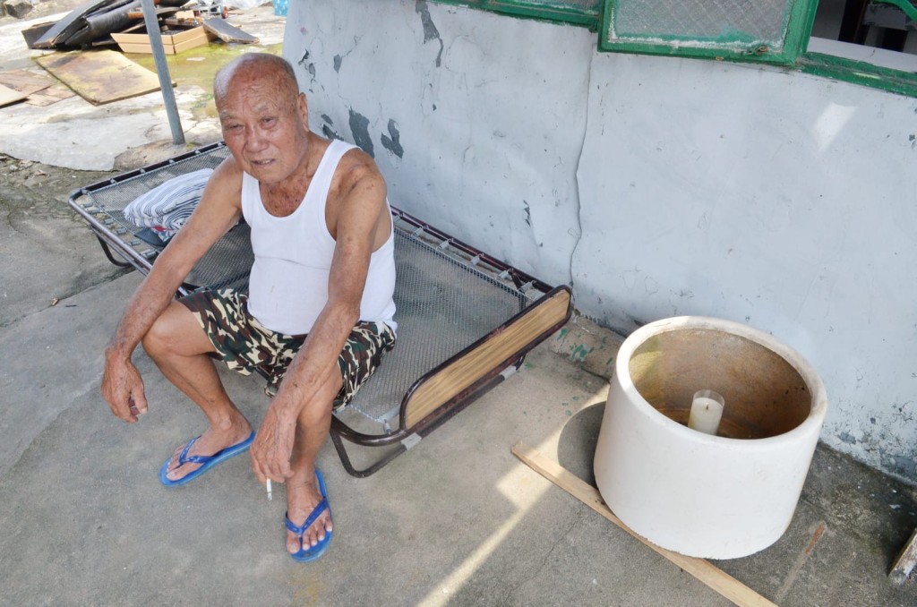 90歲的李伯剛喪妻,受訪時正坐於白蠟燭旁。