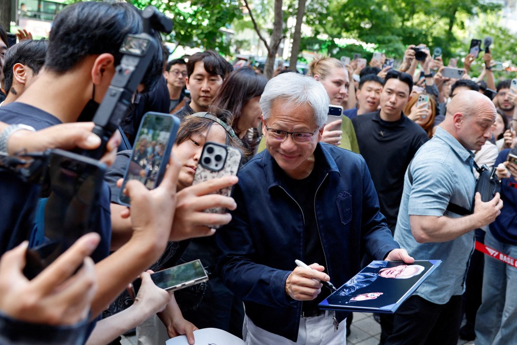 黃仁勛在韓國首爾一間網吧前與粉絲自拍。路透社