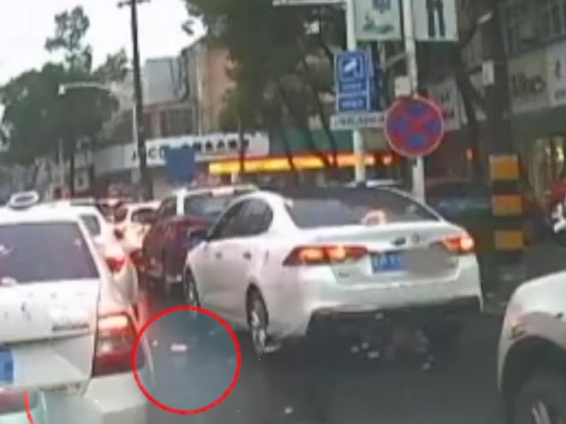 司机在一辆白色私家车伸手把胶樽、纸屑等东西从半开的车窗随手抛出。(网图)