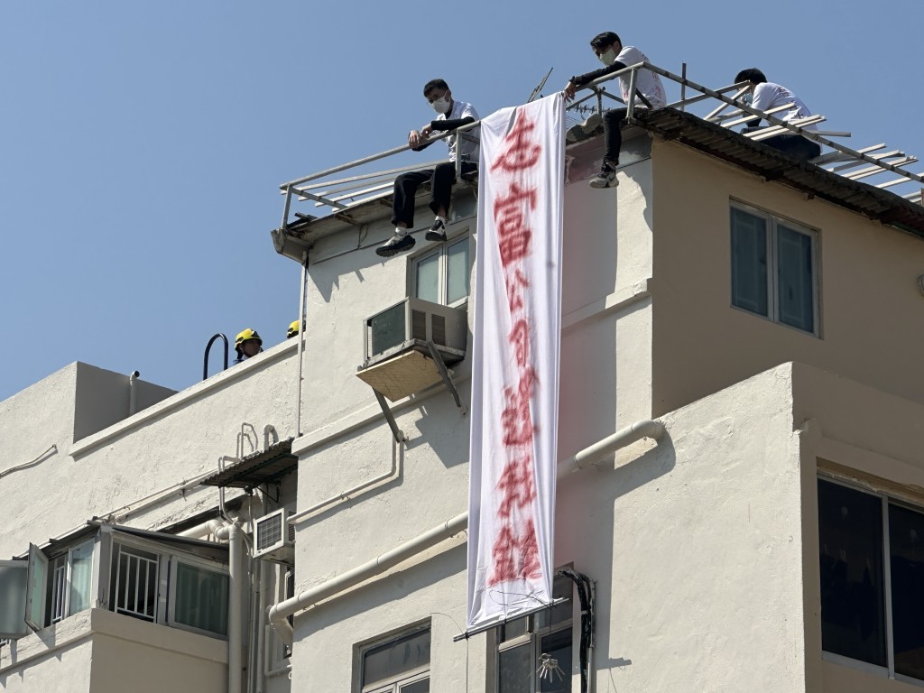 3工人危站天台邊拉橫額追欠薪。梁國峰攝