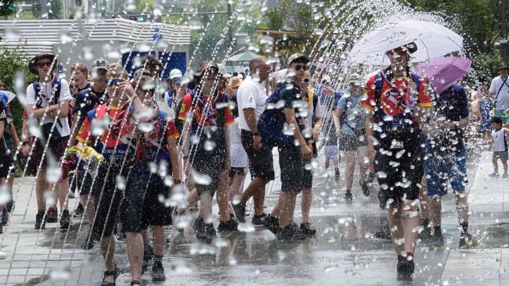首爾高溫35度，民眾走在噴泉中濕身消暑。 美聯社