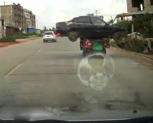 一輛三輪車竟「拓」着汽車在路上飛奔。（網圖）