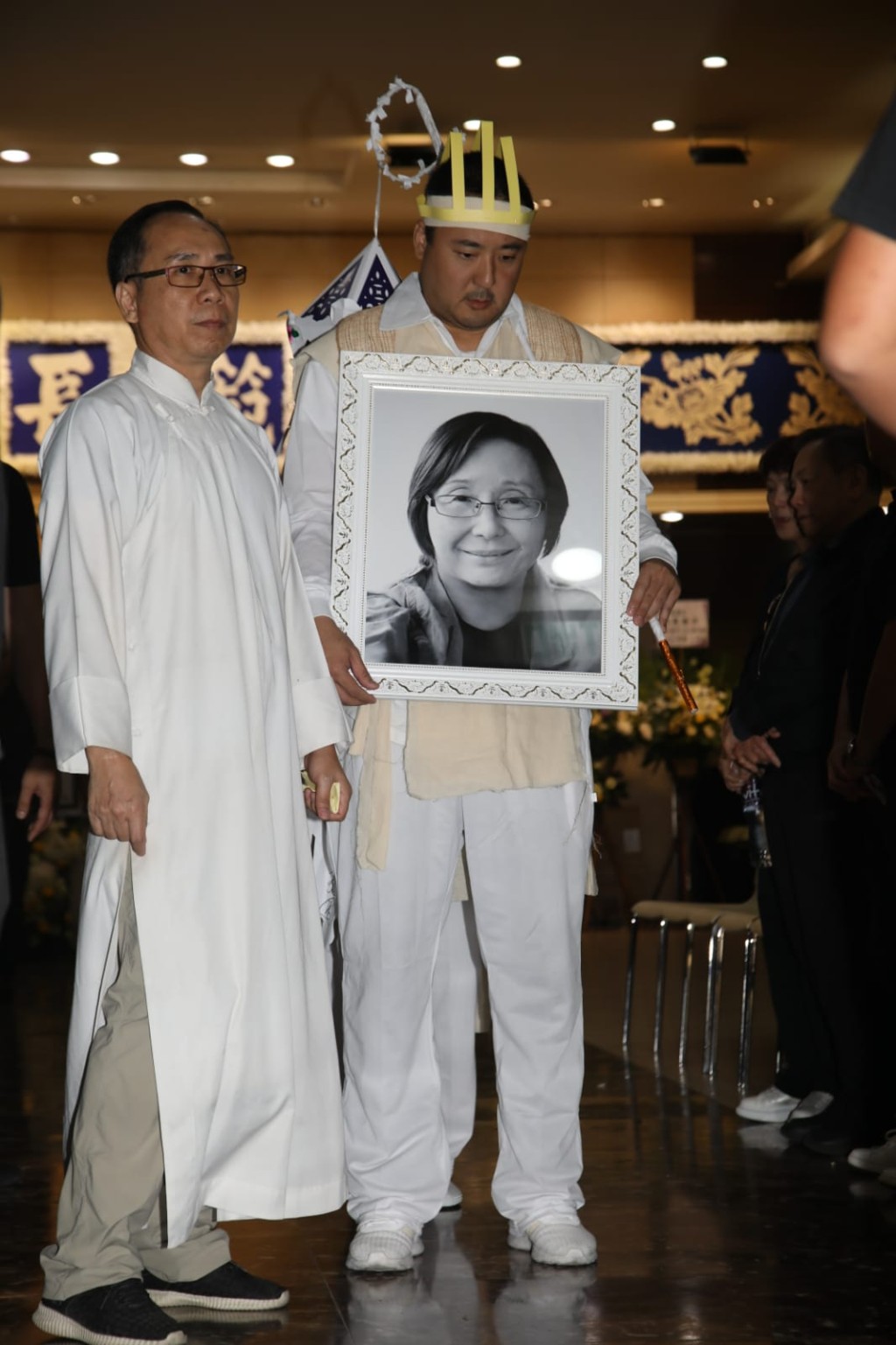 王子鳴手持母親遺照緊隨其後。