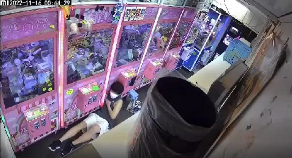為求伸盡手的長度,灰衫青年甚至緊握心口,盡量讓右手伸進出入口內。(影片截圖)