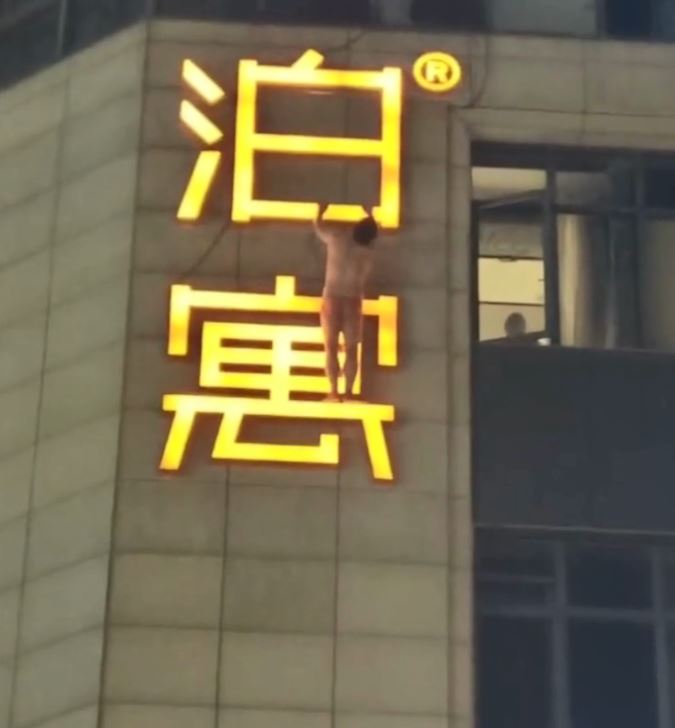 男子雙手抓住廣告牌。微博