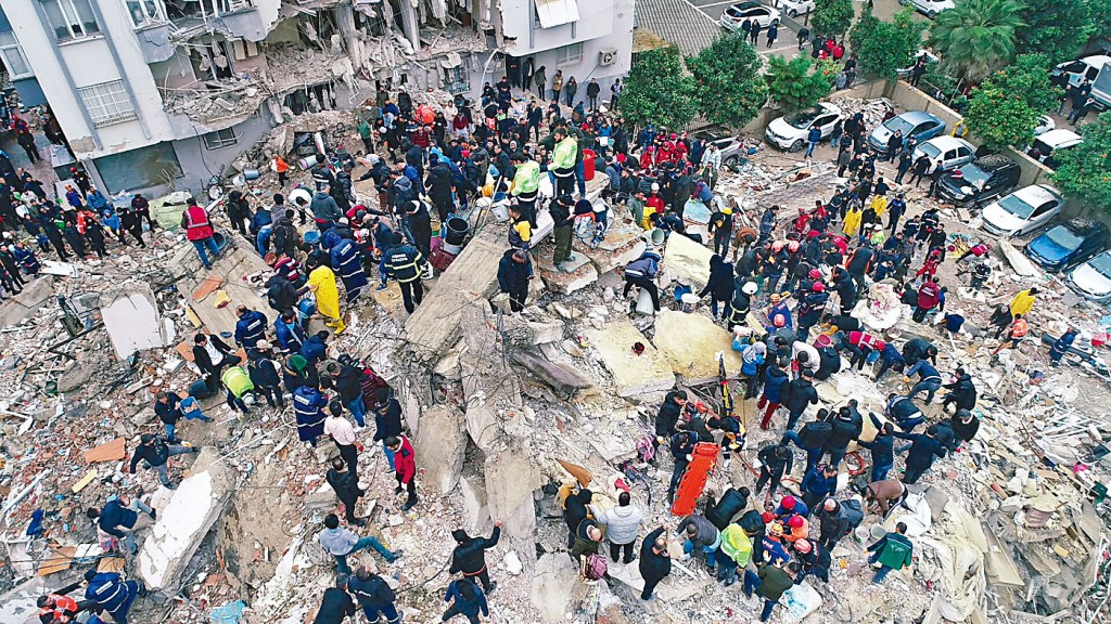 土耳其阿達納市救援人員在瓦礫下搜索生還者。　