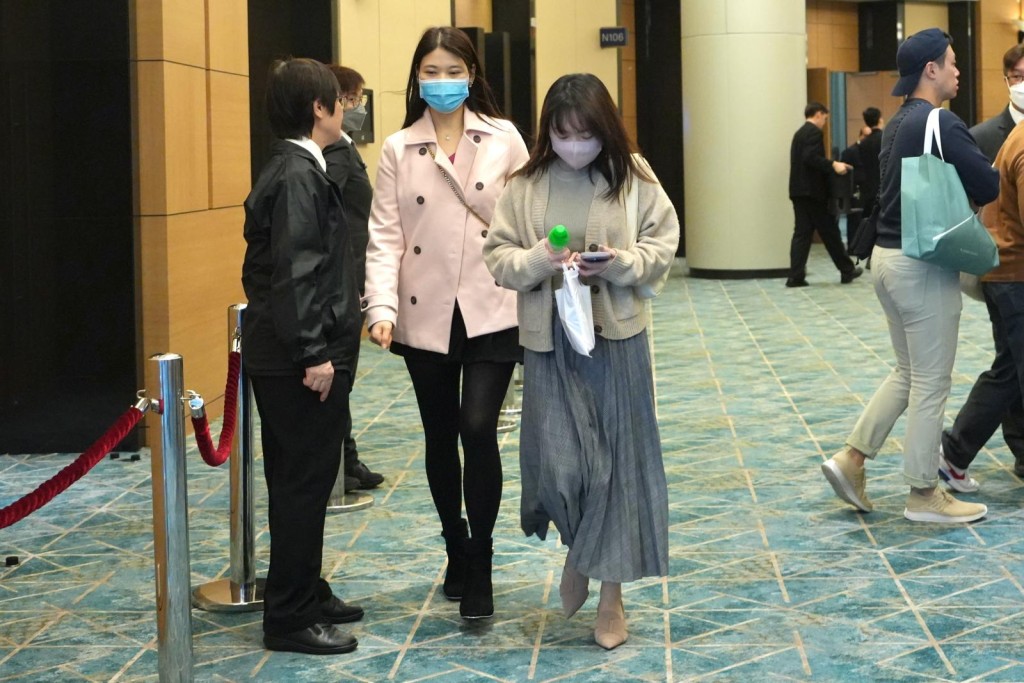 投得D字车牌的女士(右)与友人离开，并无回应记者提问。刘骏轩摄