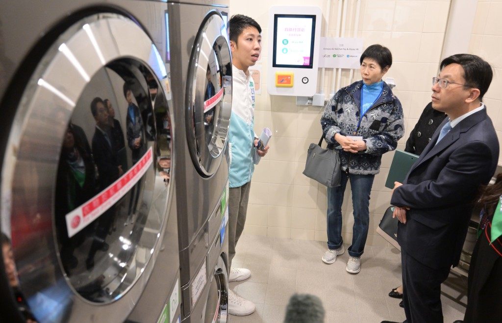 孙玉菡（右）与委员参观自助洗衣站，了解设施如何便利「劏房」户。政府新闻处图片