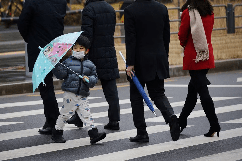 南韓雖解除室內口罩令，家長為保護小孩仍給他們戴上口罩上學。路透
