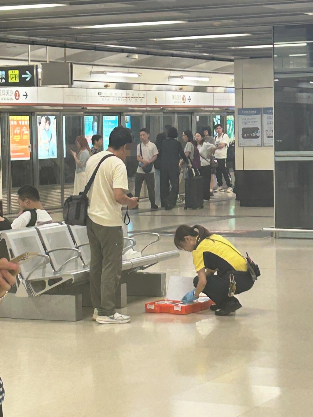 一名港鐵女職員帶同急救箱,替中年漢進行包紮。網上圖片 一名港鐵女職員帶同急救箱,替中年漢進行包紮。網上圖片