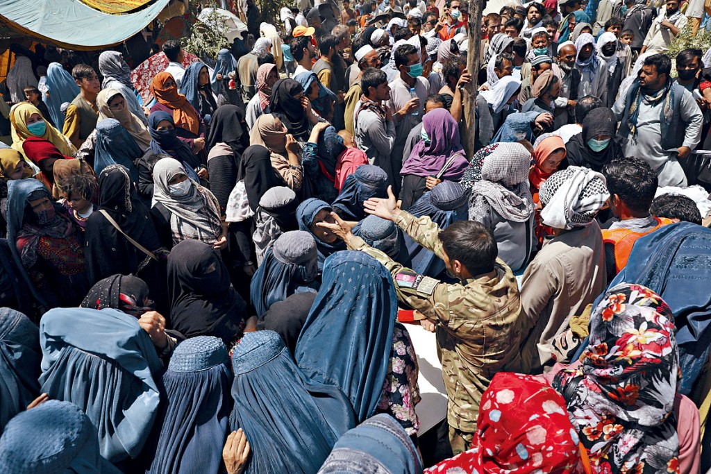 为逃避塔利班而流离失所的阿富汗民众，周二在喀布尔的公园等候免费食品。