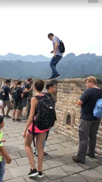 男子沿着垛口行走，最后才从垛口跳下来。（网图）