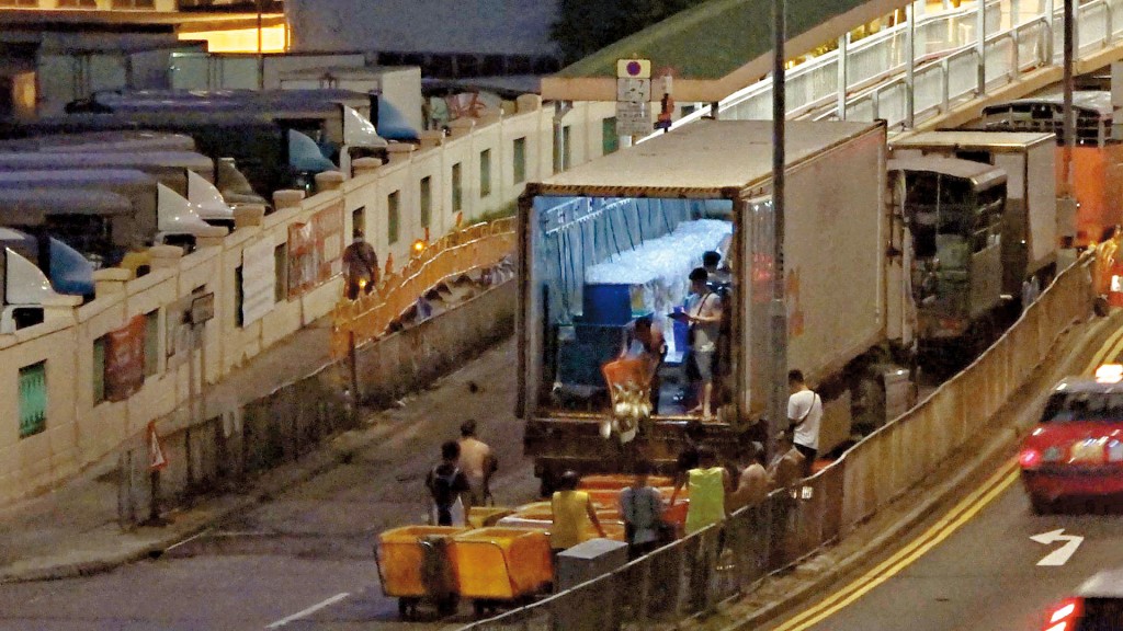 《东周刊》直击香港仔鱼市场运作当日，一架装满海鲜的货柜车在傍晚时分驶达后，多名栏商随即到货柜车前排队攞货。