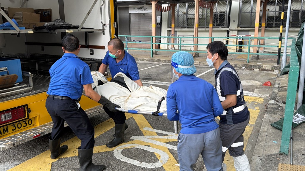 女死者遺體同由仵工送往殮房。梁國峰攝 女死者遺體同由仵工送往殮房。梁國峰攝