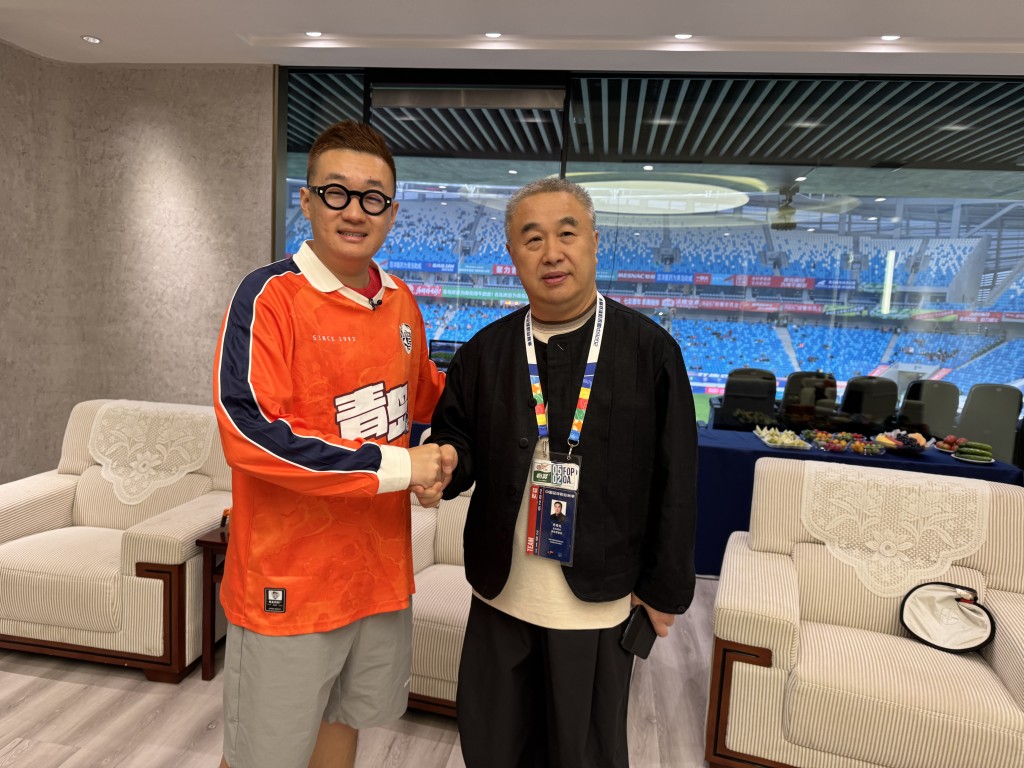 节目主持人孟繁旭与青岛海牛足球俱乐部董事长乔伟光 （右）访问后合照留念。节目组图片