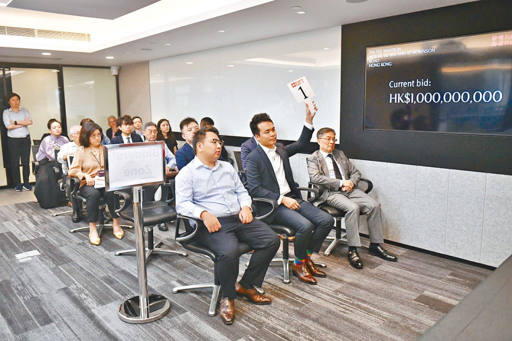 投资者伍登辉(手持一号牌)昨以底价10亿成功统一西半山燕贻大厦业权。