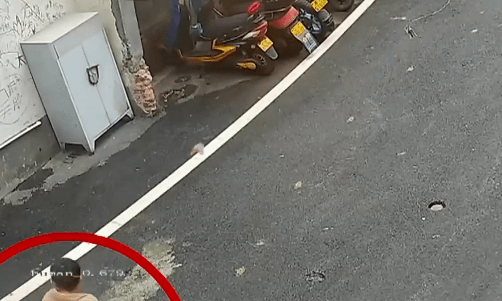 闭路电视画面显示，一名男童在电动单车停车位附近投放烟花。