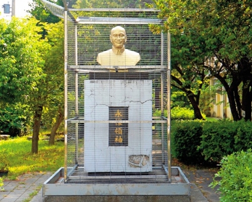 蔣介石銅像前後左右都被不銹鋼鐵籠罩住。網圖