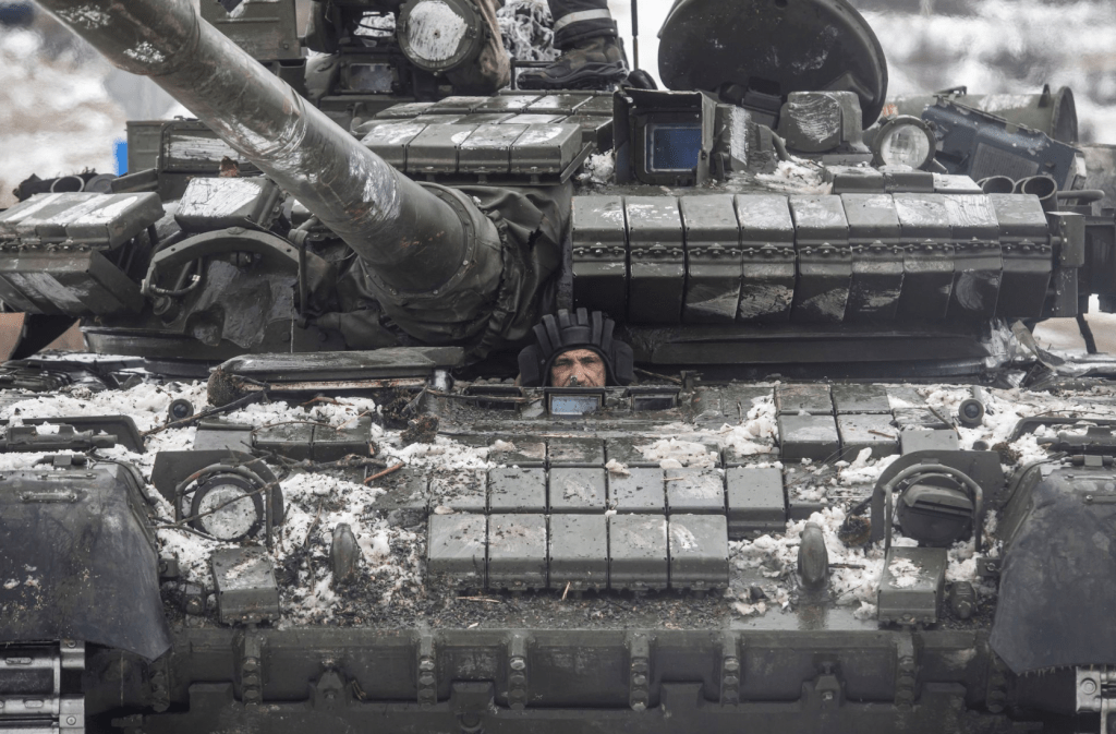 14 日，在乌克兰顿涅茨克地区，一名乌克兰军人在前线城镇 Bakhmut 外的一条道路上驾驶坦克。路透社
