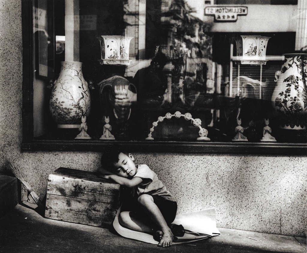 《南柯美夢》擦鞋童幹活累了，在街頭挨着箱子小睡片刻。（黑白圖片）