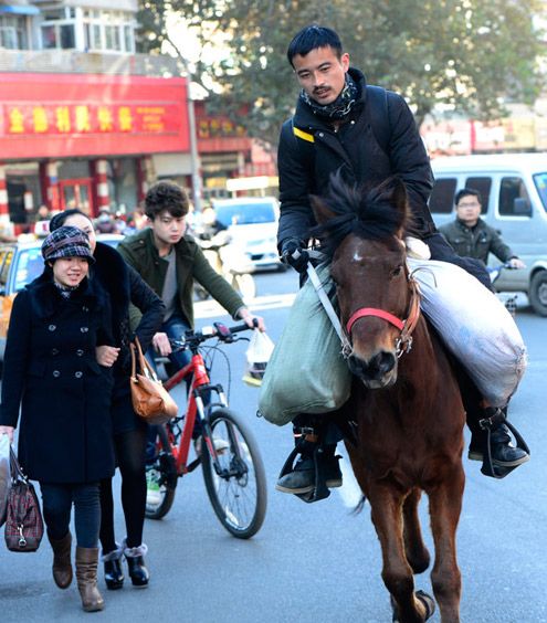 唐新宇騎馬途徑濟南市區，引來不少人的關注。 中新社