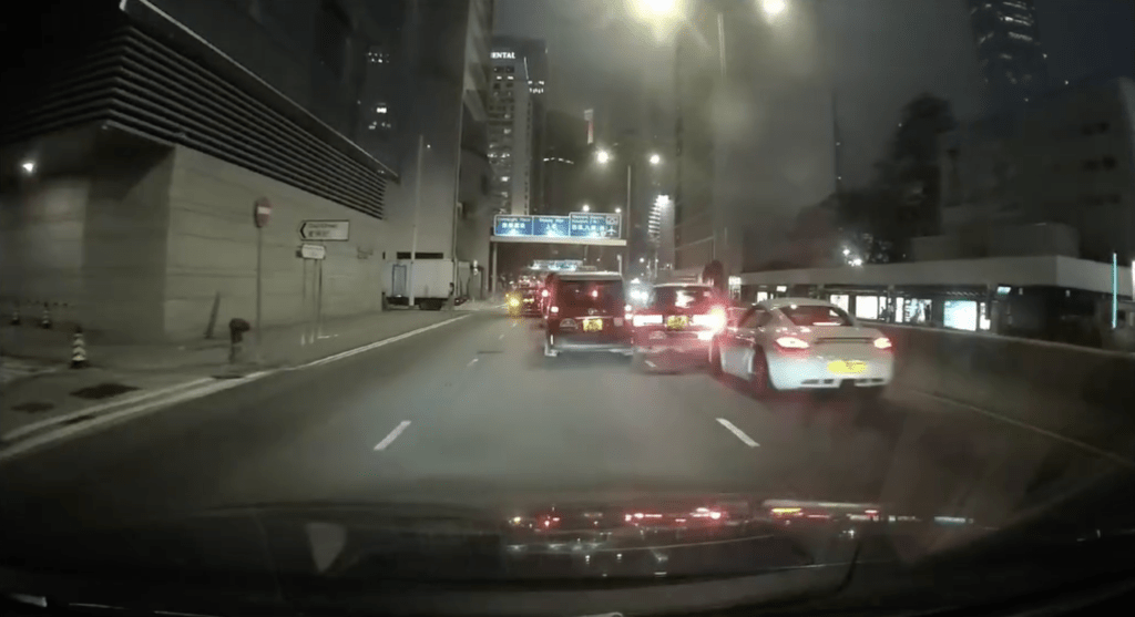 一輛的士疑打左燈切向左線期間,突然再切回右線,尾隨的保時捷收掣不及導致意外。FB車cam L(香港群組)影片截圖 一輛的士疑打左燈切向左線期間,突然再切回右線,尾隨的保時捷收掣不及導致意外。FB車cam L(香港群組)影片截圖