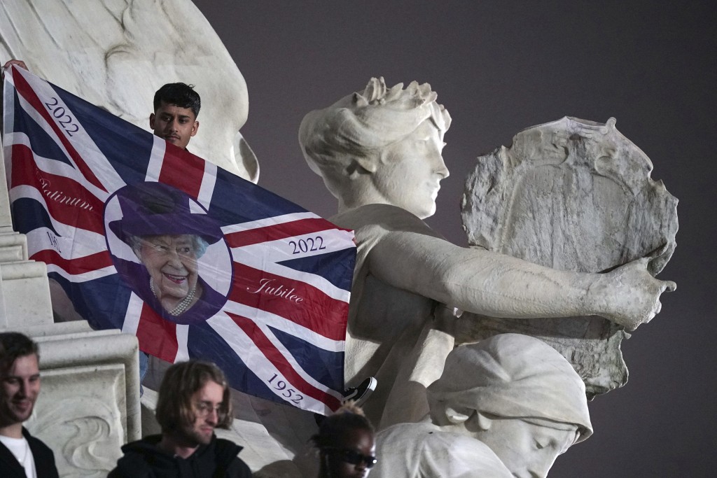 倫敦市中心白金漢宮外的維多利亞女皇紀念碑上的哀悼者。AP