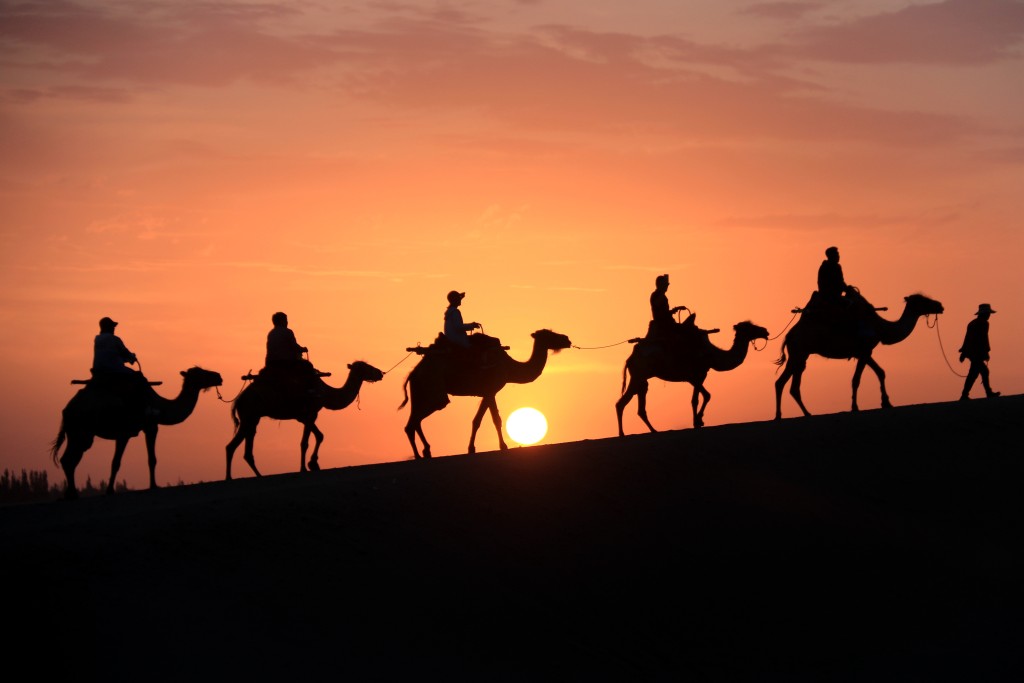甘肃敦煌鸣沙山月牙泉景区有向游客提供骑骆驼的项目。(新华社)
