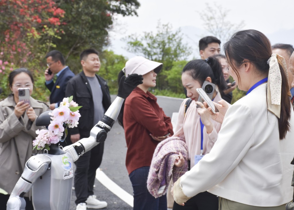 悉心打扮的機械人在景區與遊客互動。中新社 悉心打扮的機械人在景區與遊客互動。中新社