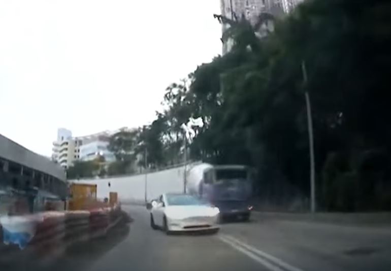 白色Tesla逆线加速，爬过田螺车车头。网上影片截图