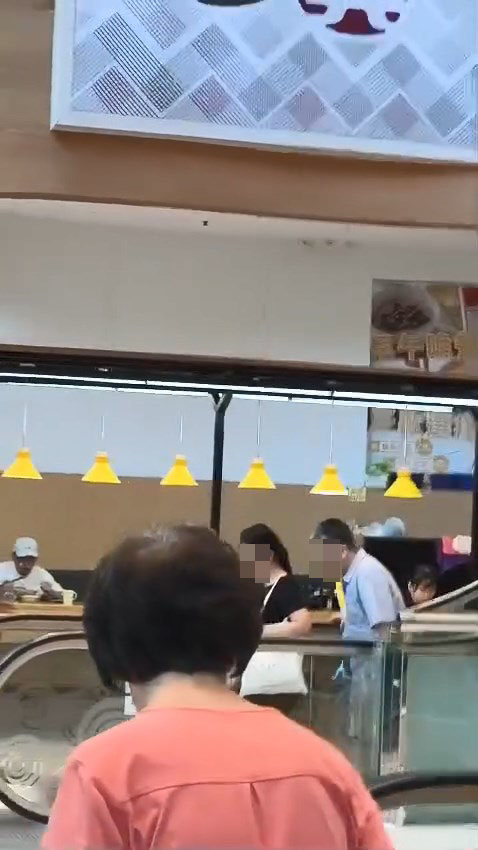 一名男子搭扶手梯時偷聞前方女子的「髮香」。網上片段截圖 一名男子搭扶手梯時偷聞前方女子的「髮香」。網上片段截圖