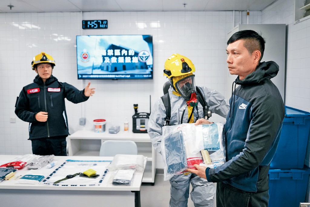 消防員向需要洗消的市民派發裝有刷子、肥皂和保護衣等的洗消包。  