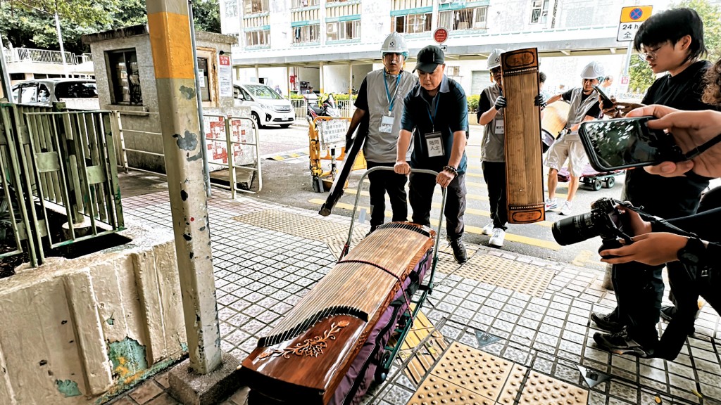 宏道閣住戶馬先生在民安隊及關愛隊協助下搬走18個古箏。
