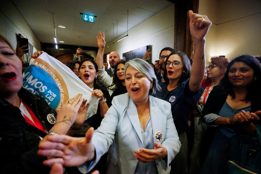 智利劳工部长贾拉（Jeannette Jara）与其他部长庆祝每周工时逐步减至40小时的法安通过。路透社