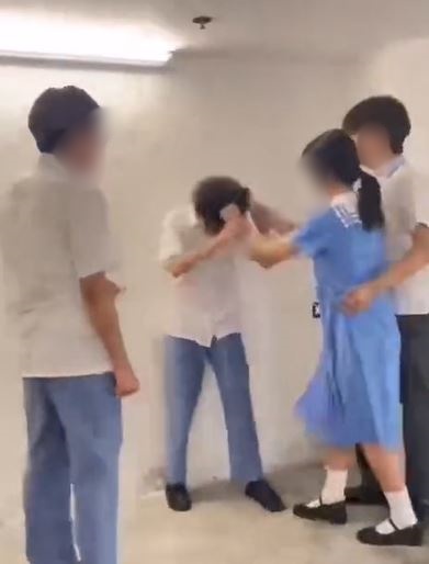 女生扯受害男生頭髮。網片截圖