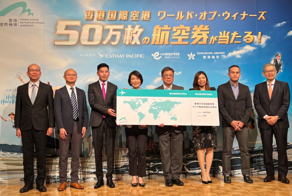丘应桦（右四）出席机管局为响应「你好，香港！」而举办「飞遇世界钜赏」赠送机票活动的传媒午宴。政府新闻处图片