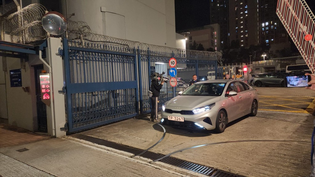 至24日凌晨零時左右，其中一名被捕男子被帶上頭套，在重案組人員押解下，由便裝警車載離田心警署。黎志偉攝